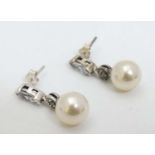 A pair of white metal drop earrings set with white stone, marcasite and pearl drops.