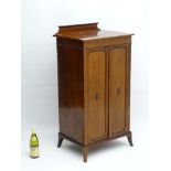 An early 20thC mahogany Sheraton Revival cabinet with raised inlaid back stand and festoon