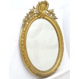 A 19thC French gilt oval mirror with floral carving throughout,