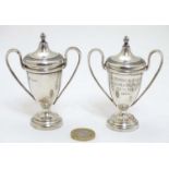 A pair of miniature twin handled trophy cups and covers hallmarked Birmingham 1932/33 maker Walker