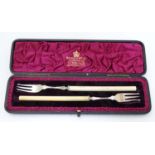 A cased pair of Victorian silver pickle forks with ivory handles.