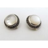 A pair of silver clip earrings set with mother of pearl bordered by marcaiste 3/4" diameter