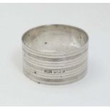 A silver napkin ring with banded engine turned decoration.