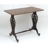 A 19thC mahogany Chippendale style table with carved scrolling supports having roundel decoration