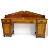 A William IV mahogany breakfront sideboard with raised triangular pediment and scrolling supports,