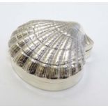 A silver pill box formed as a shell.