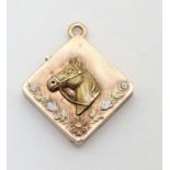 Equine Interest : A yellow metal locket of squared form with horse head floral and foliate