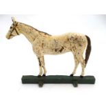 A cast iron doorstop formed as a horse with polychrome decoration.