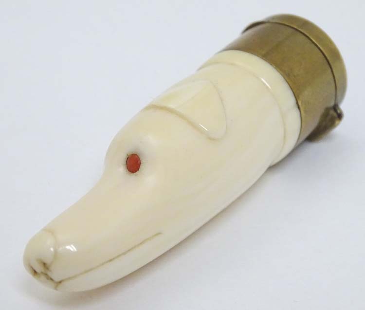 A Victorian novelty vinaigrette formed as a carved ivory dogs head with red eyes and having brass