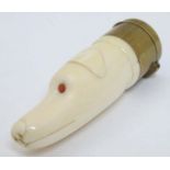 A Victorian novelty vinaigrette formed as a carved ivory dogs head with red eyes and having brass