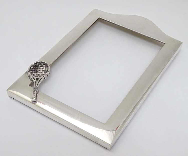 A silver photograph frame surround with tennis racket motif. Marked Sterling .