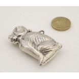 A novelty silver vesta case formed as a seated dog with hinged head and striker under.