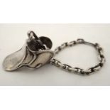 A white metal chain and pendant fob / charm formed as a miniature saddle.