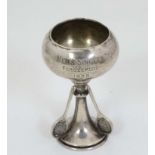 A silver trophy cup with tennis racket decoration,