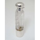A cut glass ladies hip flask of cylindrical form with silver top, mounts and beaker to lower.