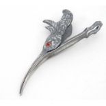 A silver plate paper clip formed as a birds head with hinged beak.