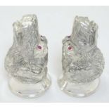 A novelty white metal salt and pepper cruet formed as dog heads set with red stone eyes. marked .