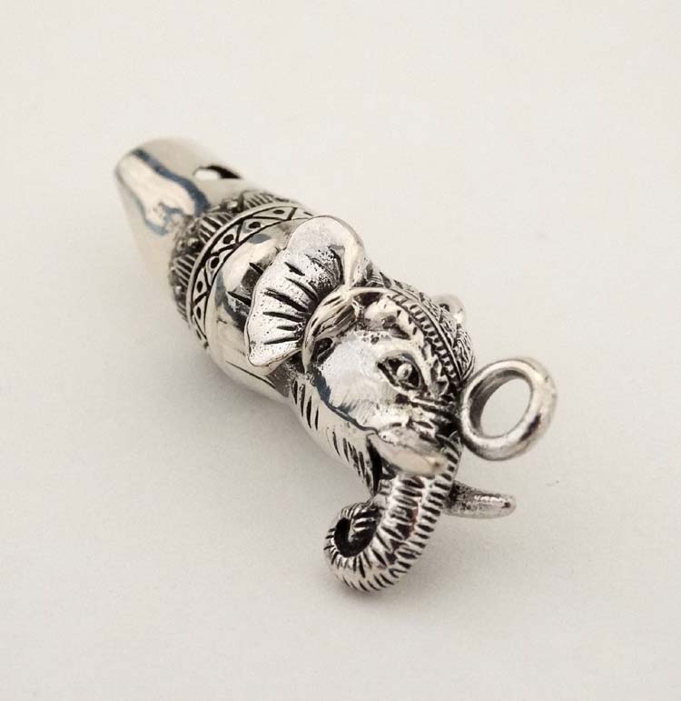 A novelty silver whistle with elephant head decoration.