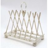 A novelty 6-slice silver plated toast rack, the bars formed as crossed golf clubs.