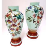 Two glass vases, the pale green ground with hand painted floral decoration.