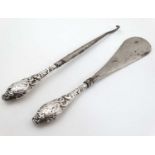 A silver handled button hook and shoe horn.