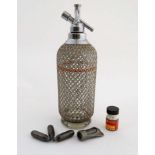 A glass soda siphon with silver plate mesh covering and mounts marked ' Sparklets Ltd.
