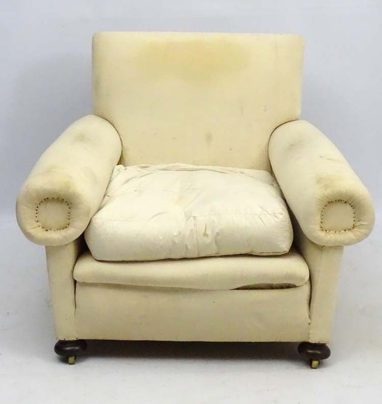 A late Victorian upholstered and overstuffed armchair with walnut bun feet. - Image 4 of 5
