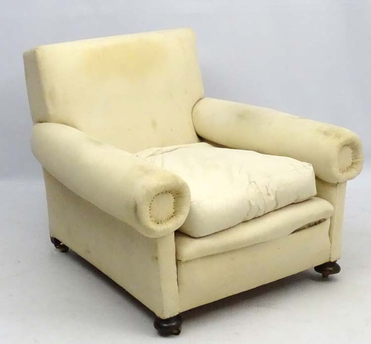 A late Victorian upholstered and overstuffed armchair with walnut bun feet.