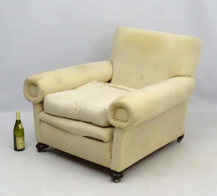 A late Victorian upholstered and overstuffed armchair with walnut bun feet. - Image 5 of 5