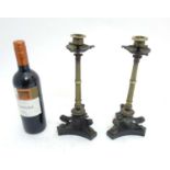 A pair of Empire? three footed bronze and brass candlesticks with triform slate bases.