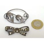 An Art Nouveau white metal brooch together with a silver brooch of bow form.