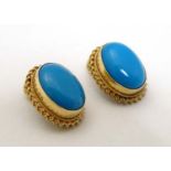 A pair of 9ct gold clip earrings set with turquoise cabochon.