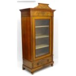 An early 20thC walnut vitrine with large glazed door, single long drawer,