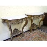 A pair of 19thC Louis XVI style gilt wood console tables with shaped marble tops.