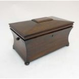 A Georgian Rosewood tea caddy of sarcophagus form with waisted sides opening to reveal 2 caddies
