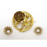 A gilt metal brooch with floral decoration and a pair of earrings with pearls to centre