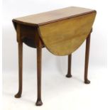 A Georgian mahogany drop leaf table of small proportions and oval form,