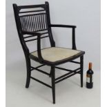 An Aesthetic Movement ebonised open armchair in the manner of E.W.