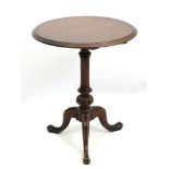 An early 19hC mahogany tripod occasional table with a turned tapering central column with carved