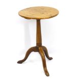 An 18thC elm wine table with a turned tapering base, standing on a tripod base.