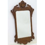 A Georgian style walnut wall mirror having decoratively carved frame with applied shell motif.