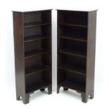 A pair of early 20thC free standing bookcases with burr walnut tops and standing on shaped bracket