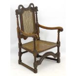 A 17thC oak armchair with caned backrest and seat,