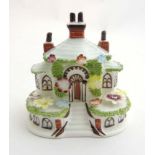 A Coalport fine bone china 'Keepers Cottage' ornament embellished with flowers and grass.