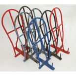 A pale blue wall mounted plastic coated , tubular steel standard size saddle rack,