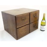 An early 20th C oak four drawer table top filing cabinet, with sliding sections within,
