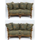 A pair of mid 20thC curved back Settee's having caned sides and Morris style upholstery and