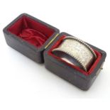 A silver napkin ring with engraved decoration and beaded border.