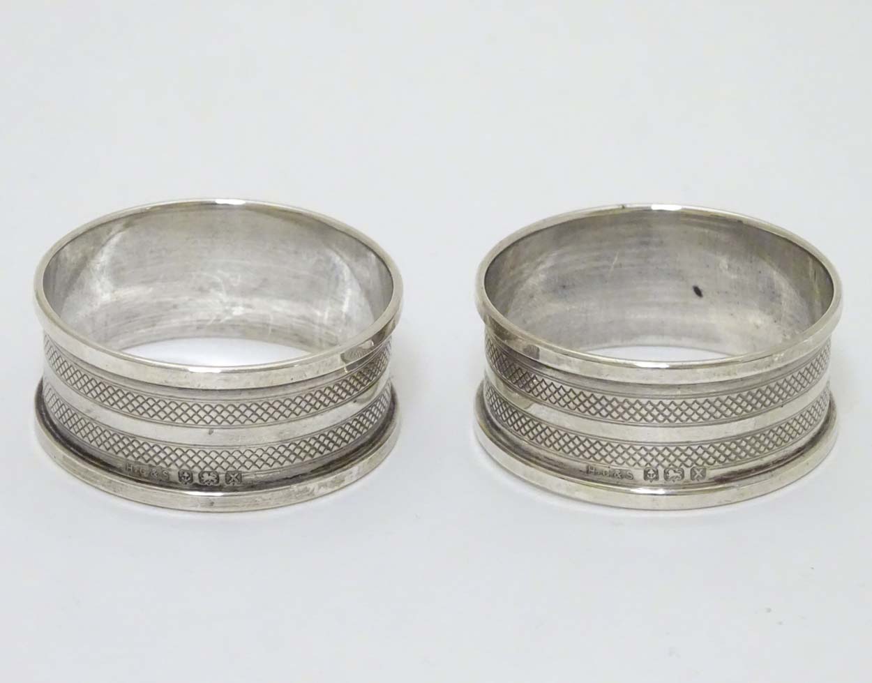 A pair of silver napkin rings with banded engine turned decoration hallmarked Birmingham 1947 maker
