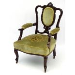 A Victorian open armchair with decoratively carved cresting rail,